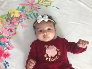 Photo of baby girl dressed in red long-sleeved dress with headband
