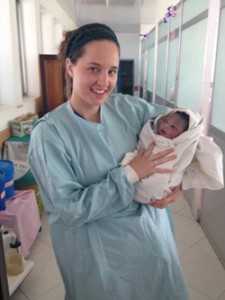 Hannah Smith '14 cradling a newborn