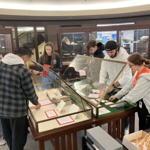 Students arrange archival material in exhibit cases.
