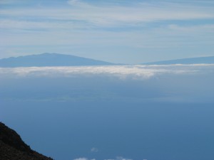 Muana Kea and Muana Loa visible above the clouds, with more of the Big Island visible beneath the clouds.